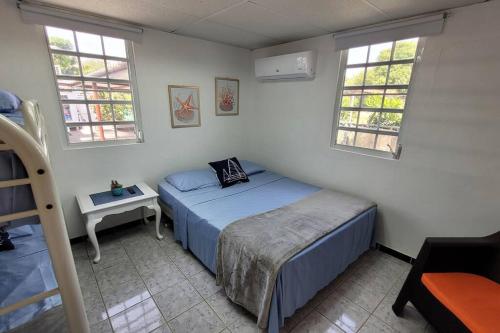 Un dormitorio con una cama y una mesa y dos ventanas. en El Faro Apart with Jacuzzi AC free Wifi Fully Equipped, en Pole Ojea