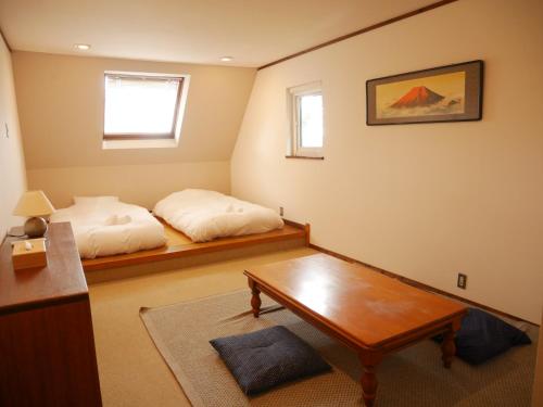 a bedroom with a bed and a table in it at Wonder Lodge Niseko in Niseko