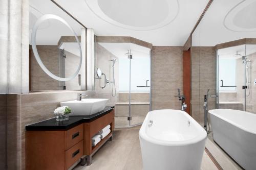 a bathroom with a toilet and a sink and a tub at Suzhou Marriott Hotel in Suzhou