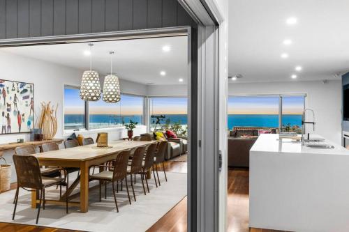 a dining room and kitchen with a table and chairs at Luxury Beach Views on the Terrace sleeps 10 in Ocean Grove