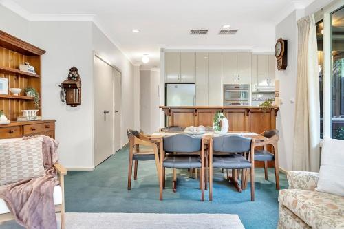 a kitchen and dining room with a table and chairs at Picket Fence Cottage - Steps from Adelaide Oval in North Adelaide