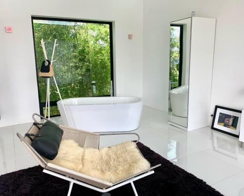 a bathroom with a tub and a large window at White Lagoon in Hua Hin