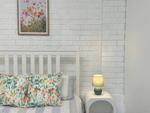 Una cama con una almohada y una lámpara sobre una mesa. en Macgregor 2bed studio 3ELC, en Brisbane