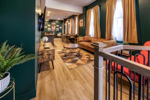 ein Wohnzimmer mit grünen Wänden und einem Sofa in der Unterkunft North House - Majestic 3-Bedroom Designer Apartment in Québec