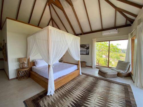 a bedroom with a bed with a canopy at Rote Island Lodge in Nembrala