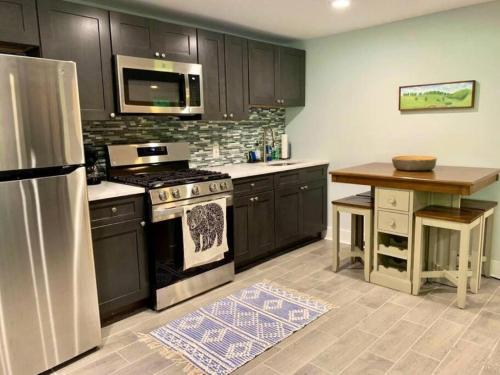a kitchen with black cabinets and a stainless steel refrigerator at The Suite at Pound Ridge in Pound Ridge
