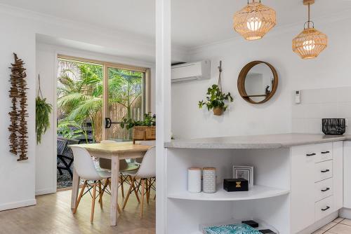 a kitchen and dining room with a table and chairs at Byron Lakeside Holiday Apartments in Byron Bay