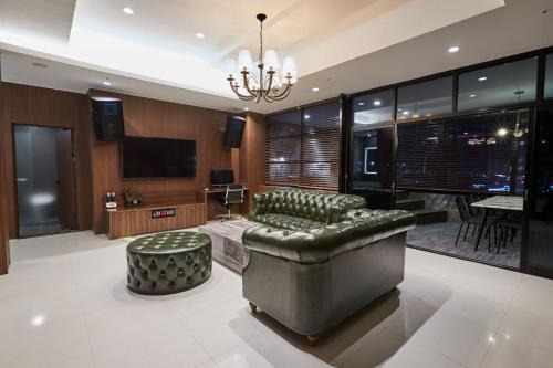 a living room with a couch and a television at Suwon Partyz Hotel in Suwon