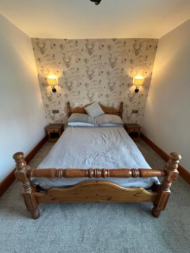 a bedroom with a wooden bed with two lamps at Cosy Bay Cottage in Scarborough
