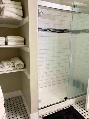 a bathroom with a glass shower with towels on shelves at The Suite at Pound Ridge in Pound Ridge