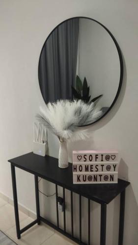 a mirror on top of a black table with a mirror at Sofia's Homestay - For MusLiiM in Kuantan