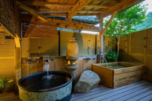 a bathroom with a bath tub and a sink at Ryokan Ohashi in Misasa