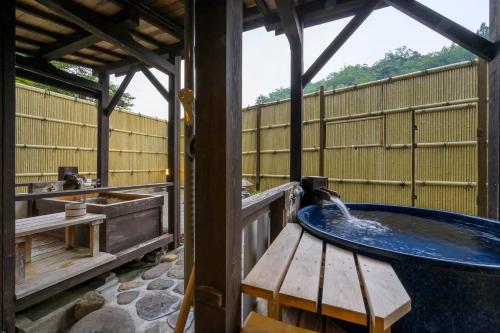 a bath tub with water coming out of it at Ryokan Ohashi in Misasa