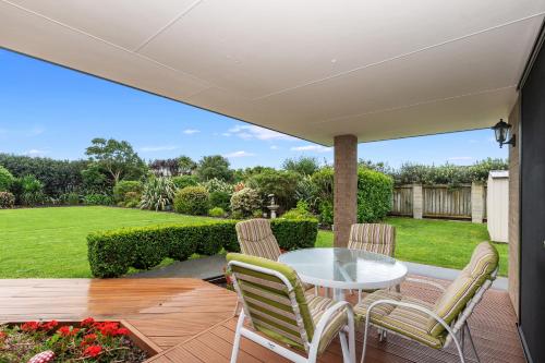 a patio with a white table and chairs at Magical Waipu - Central Family Holiday Home in Waipu