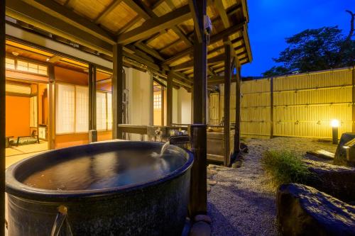 a bath tub sitting outside of a house at night at Ryokan Ohashi in Misasa