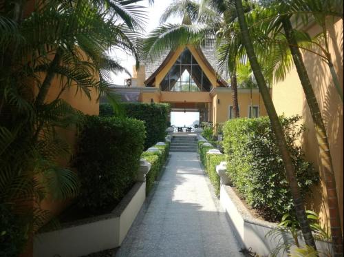 una passerella di fronte a un edificio con palme di Blue Haven Bay Villa 21D and Resort Apartments a Ko Chang