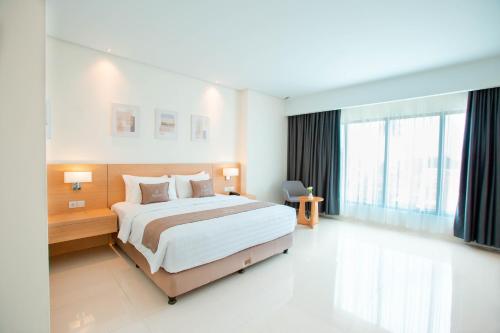 a bedroom with a large bed and a large window at Hilani Boutique Hotel in Luengbata