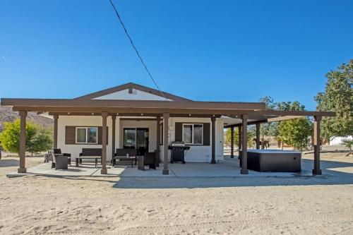 a pavilion with a table and chairs in front of a building at Ranch House with Lap Pool Biking & Running Course in Desert Hot Springs