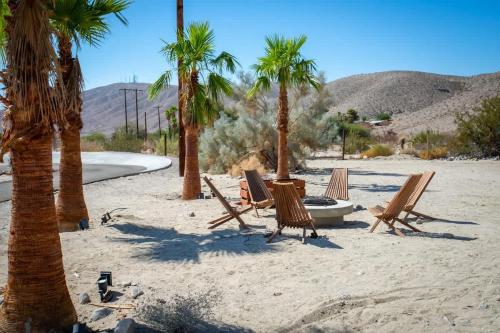 a group of chairs and palm trees on a beach at Ranch House with Lap Pool Biking & Running Course in Desert Hot Springs