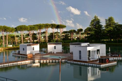 a house on the water with a rainbow in the background at Villaggio La Pescaccia in San Clemente
