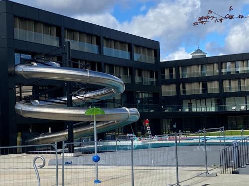 un grand bâtiment avec toboggan en face d'une piscine dans l'établissement Superbe chambre parentale avec sa propre salle de bains avec douche et wc privés, cuisine et Wifi, à Vandœuvre-lès-Nancy