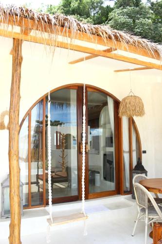 a patio with glass doors and a table and chairs at Cape Beach Villa Samui in Ban Bang Po