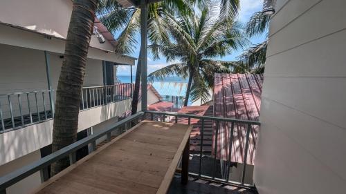 a balcony with a view of the ocean and palm trees at Skybar Koh Rong in Koh Rong