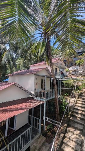a house with a palm tree in front of it at Skybar Koh Rong in Koh Rong