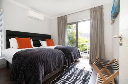 2 camas en un dormitorio con ventana en House La Gratitude - secure parking, en Stellenbosch