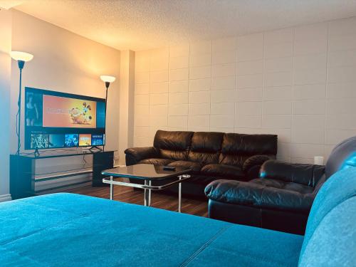 a living room with a couch and a tv at Cozy 2 Bedroom Condo with Parking in Calgary