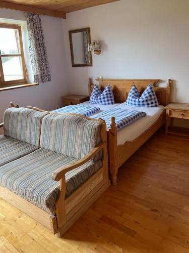 a bedroom with two beds with blue and white pillows at Ferienwohnung am Bauernhof in Otterfing