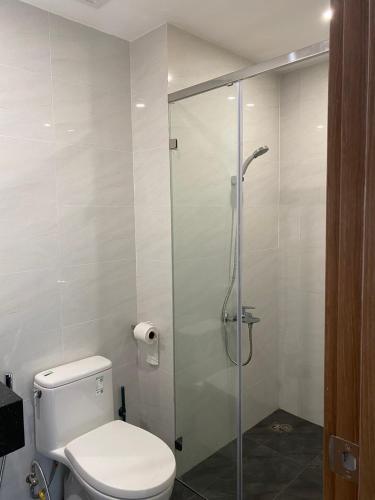 a bathroom with a toilet and a glass shower at Happy One Central - Thủ Dầu Một Binh Duong in Ấp Phú Thọ