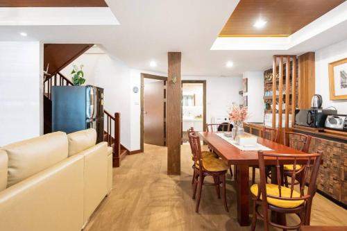 a kitchen and dining room with a table and a couch at MIQ Rama9 Villa 3Br in City Jodd fair MRT in Makkasan
