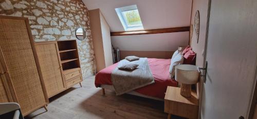 a small bedroom with a red bed and a window at La Grange in Verlincthun