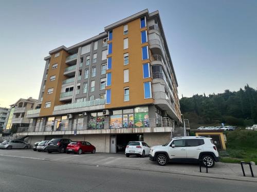 a large building with cars parked in a parking lot at AS Apartment in Podgorica
