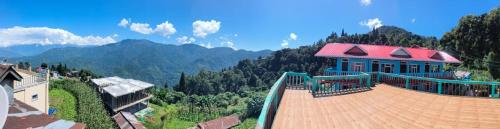 a building with a red roof on top of a mountain at Rishop Mountain Homestay in Rishop