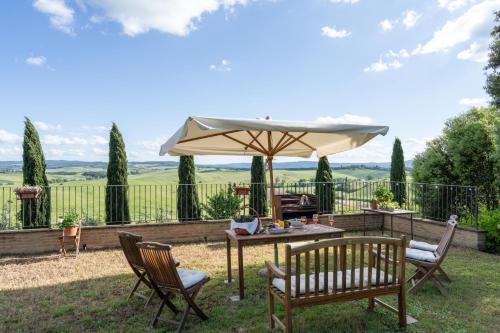 a patio with a table and an umbrella at La Capanna di Elfo luxury villa View in Siena