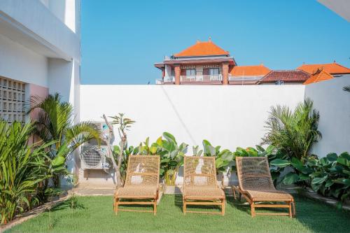 a group of chairs in a yard with a building at NEW Canggu Modern 3BR Villa with big Pool & Garden in Umalas