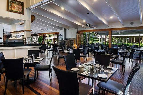 a restaurant with tables and chairs and a bar at Noosa Resort & Spa in Noosaville