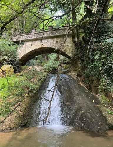 a bridge over a creek with a small waterfall at Appartamento Luzzi in Tagliacozzo