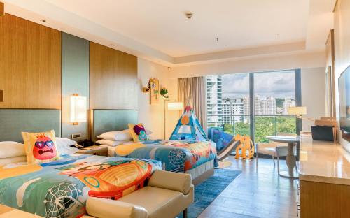 三亜市にあるJW Marriott Hotel Sanya Dadonghai Bayのベッド2台と子供用ブランコ付きの客室です。
