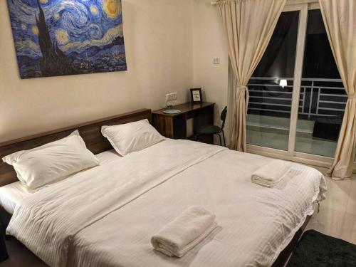 una camera da letto con un letto con due asciugamani sopra di Pednekar's House, 1BHK with pool by SneekoStays a Nerul