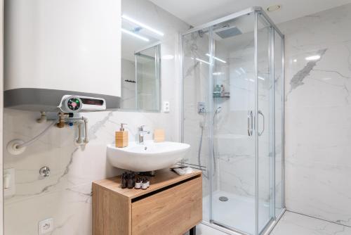 a bathroom with a sink and a shower at Apartmány Resort Vrchlabí in Vrchlabí