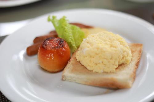 a white plate of food with a tomato and bread at Swanee Grand in Negombo