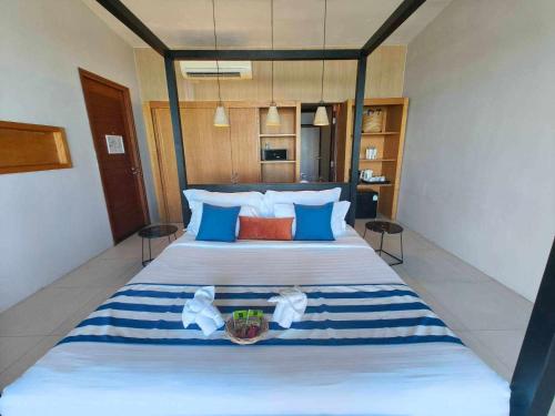 a bedroom with a large bed with blue and white pillows at Casa De Mar - Koh Samui in Chaweng