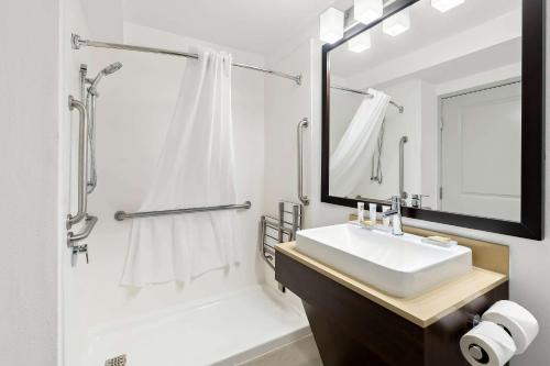 a white bathroom with a sink and a mirror at Country Inn & Suites by Radisson, Columbia Airport, SC in Columbia