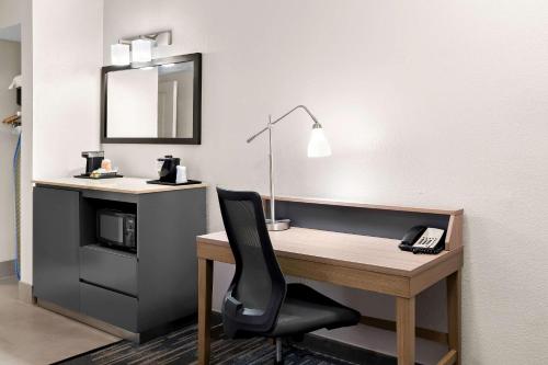 a desk with a phone and a chair in a room at Country Inn & Suites by Radisson, Columbia Airport, SC in Columbia