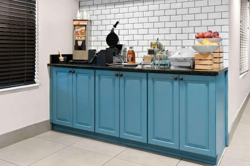 a kitchen with blue cabinets and a counter top at Country Inn & Suites by Radisson, Columbia Airport, SC in Columbia