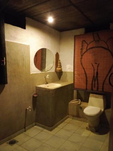 a bathroom with a sink and a toilet and a mirror at Eco Lodge Safari in Karuwalagaswewa