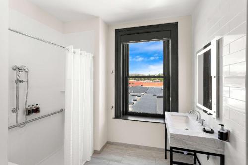 a bathroom with a window and a sink and a shower at Tygart Hotel, an Ascend Collection Hotel in Elkins